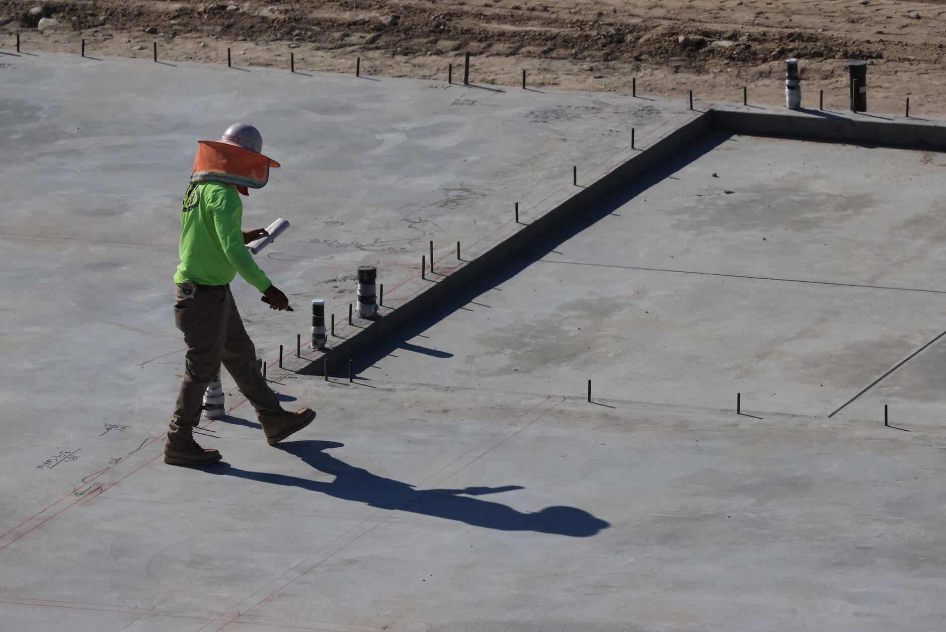 Engineer inspecting concrete slab at construction site