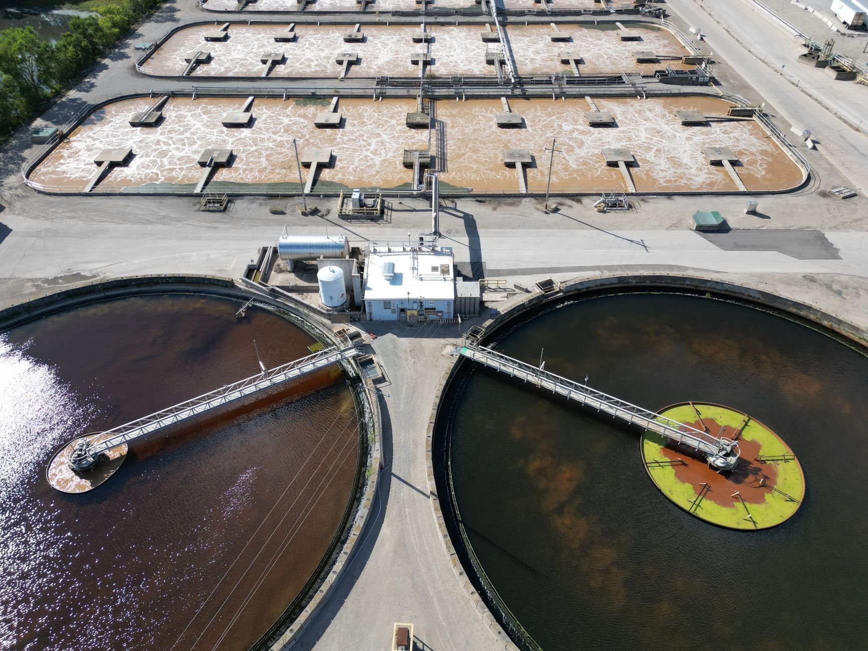 Aerial view of industrial effluent treatment plant with large circular settling tanks
